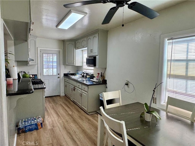 kitchen featuring gray cabinetry, sink, ceiling fan, and light wood-type flooring