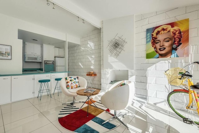 bathroom with beam ceiling, rail lighting, tile patterned floors, and tile walls