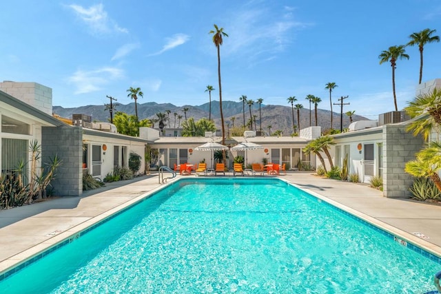 view of pool with a mountain view and a patio