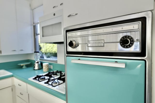 kitchen featuring white cabinetry and white appliances