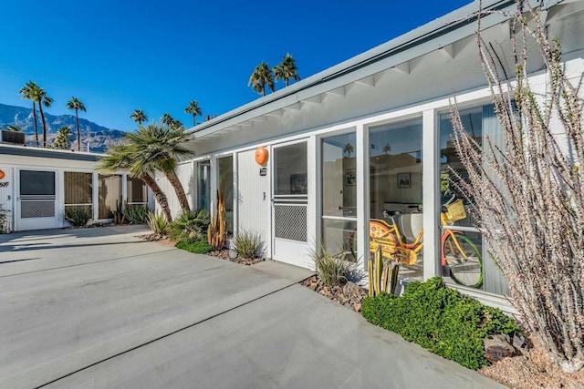 property entrance with a mountain view and a patio