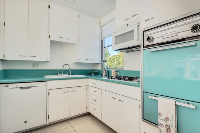 kitchen with sink, white cabinets, white appliances, and light tile patterned floors