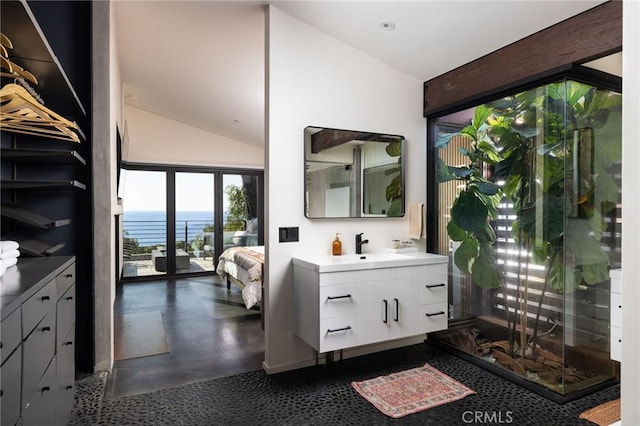 bathroom featuring vanity, a water view, and lofted ceiling