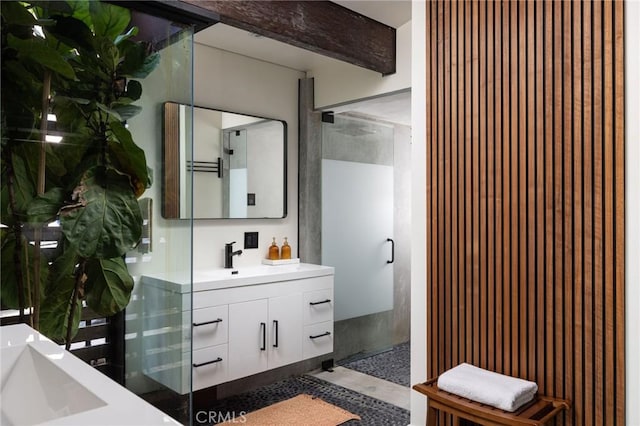 bathroom with beam ceiling, vanity, and walk in shower