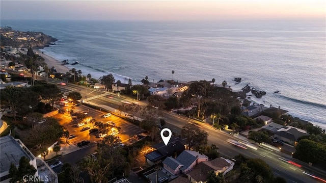 aerial view at dusk featuring a water view