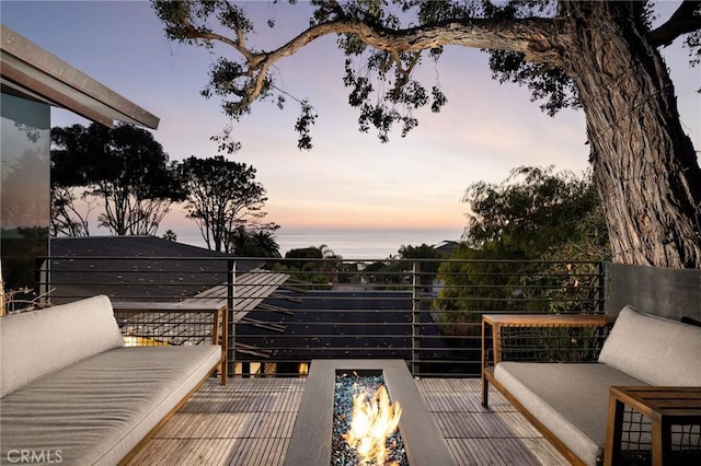 deck at dusk featuring a water view