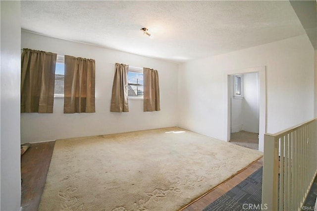 unfurnished room featuring a textured ceiling and dark wood-type flooring