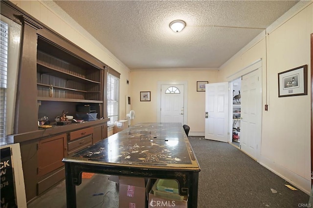 interior space featuring dark carpet and a textured ceiling