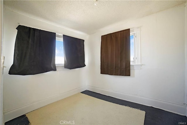 unfurnished room featuring plenty of natural light and a textured ceiling