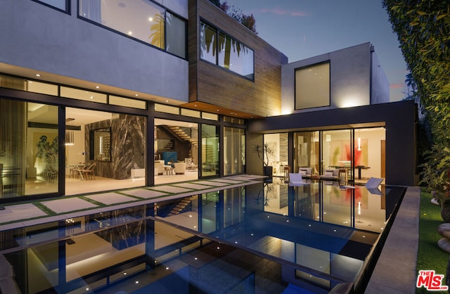 pool at dusk with a patio