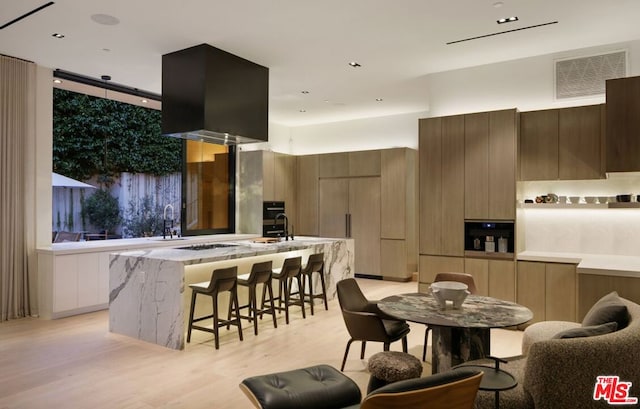 dining space featuring light wood-type flooring and sink