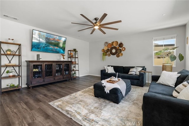 living room featuring dark wood-type flooring and ceiling fan