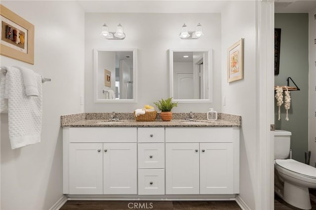 bathroom featuring vanity, hardwood / wood-style floors, and toilet