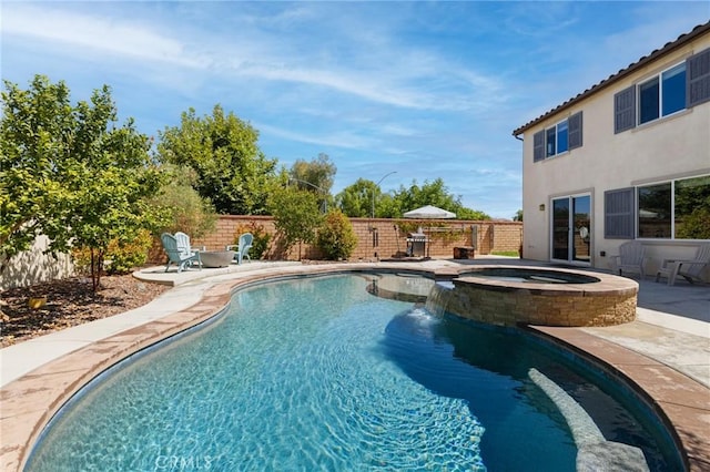 view of pool with a patio, pool water feature, and an in ground hot tub