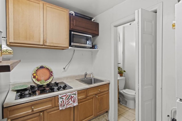 kitchen featuring light tile patterned floors, black gas stovetop, and sink