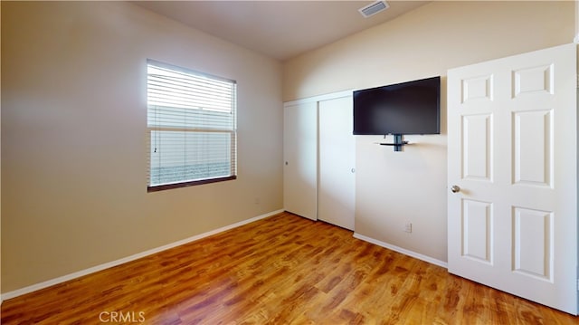 unfurnished bedroom with hardwood / wood-style flooring and a closet