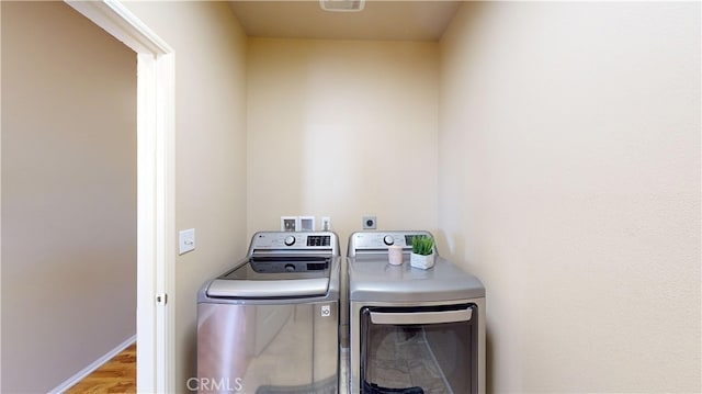 washroom with light hardwood / wood-style floors and independent washer and dryer