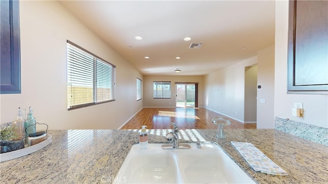 kitchen featuring light stone counters and sink