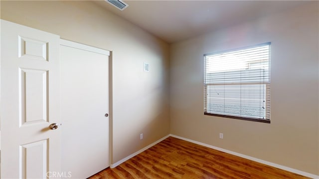 unfurnished room with hardwood / wood-style flooring