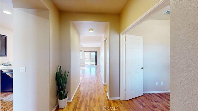 hallway with light hardwood / wood-style floors