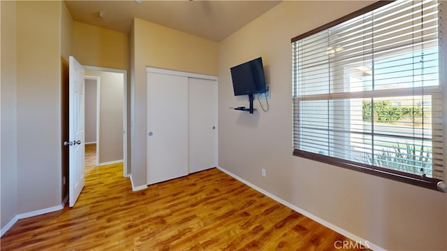 unfurnished bedroom with a closet and hardwood / wood-style floors