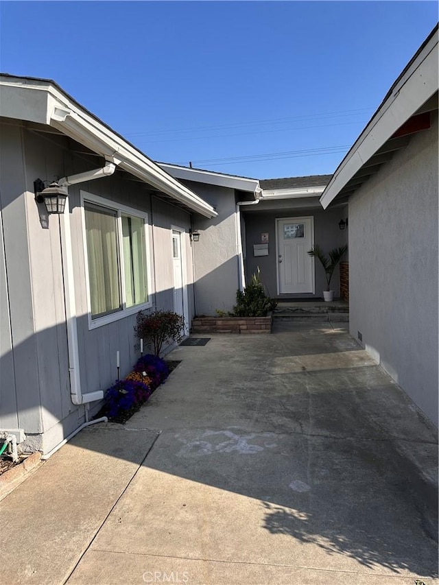 doorway to property featuring a patio and stucco siding