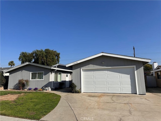 ranch-style house featuring a front yard, driveway, and an attached garage