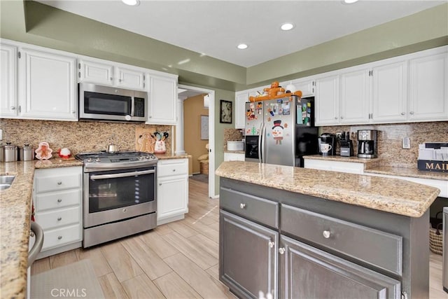 kitchen featuring white cabinetry, light stone counters, and appliances with stainless steel finishes