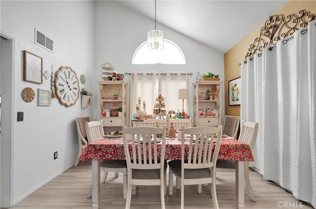 dining area with light wood-type flooring and high vaulted ceiling