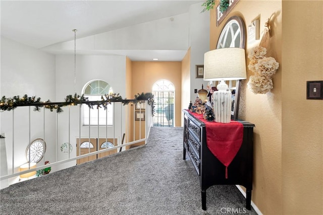 hallway featuring carpet and high vaulted ceiling