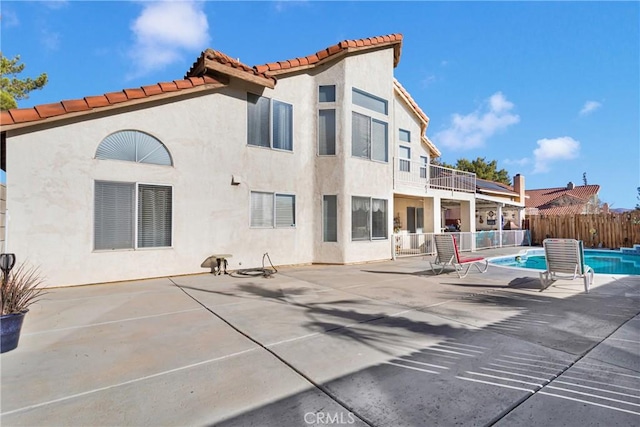 back of property with a patio and a fenced in pool