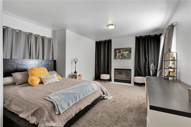 bedroom with carpet and a tile fireplace