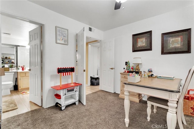 carpeted home office with ceiling fan