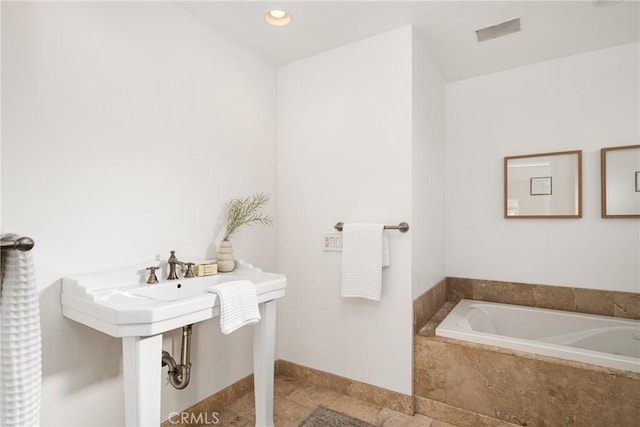 bathroom featuring a relaxing tiled tub