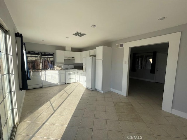 kitchen featuring white cabinets, light tile patterned floors, white appliances, and sink