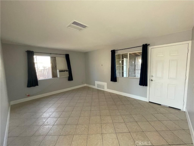 unfurnished room featuring cooling unit and light tile patterned flooring