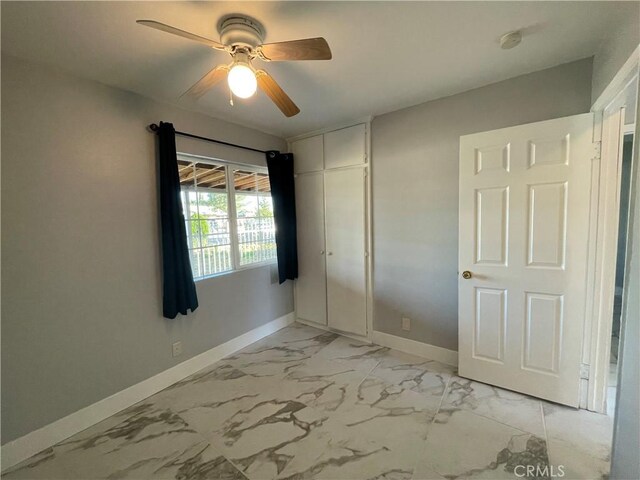 unfurnished bedroom with ceiling fan and a closet