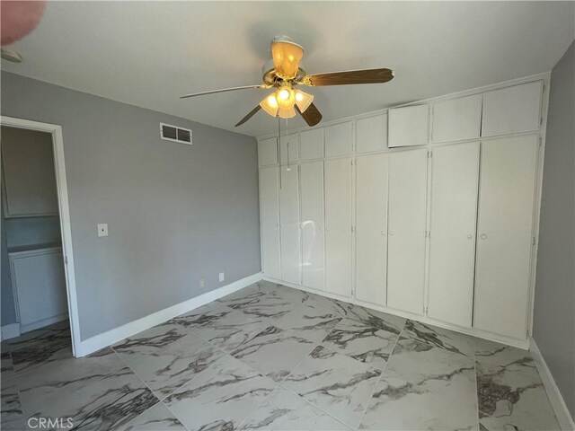 unfurnished bedroom featuring ceiling fan and a closet