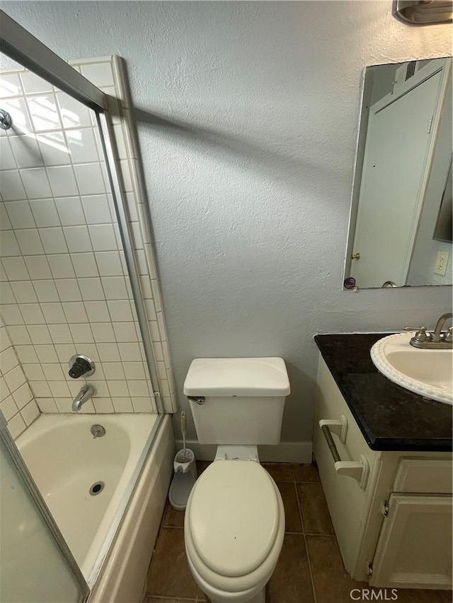 full bathroom featuring tile patterned flooring, vanity, tiled shower / bath combo, and toilet