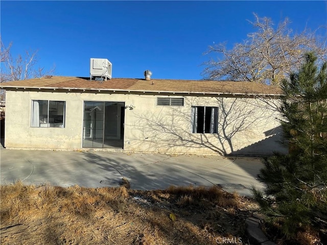 rear view of property with cooling unit and a patio area