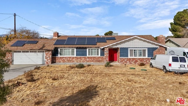 single story home featuring solar panels and a garage