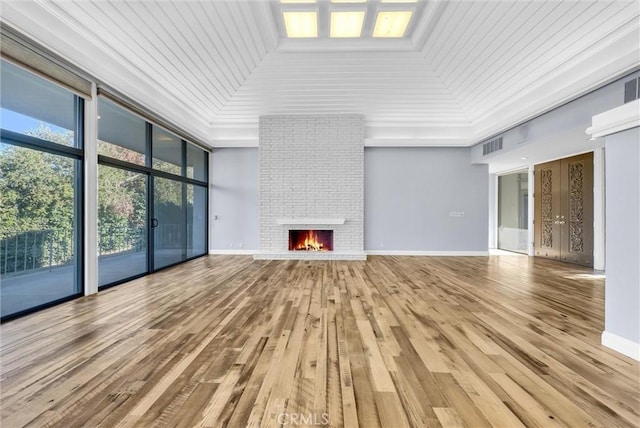 unfurnished living room featuring a fireplace, hardwood / wood-style flooring, ornamental molding, and wood ceiling