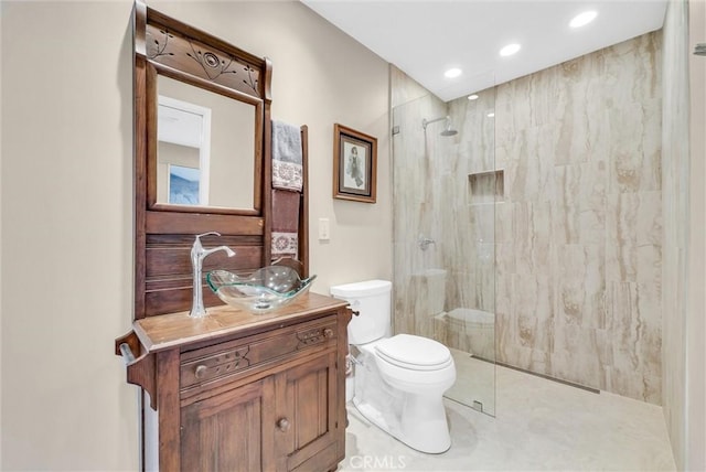 bathroom with tile patterned flooring, vanity, toilet, and tiled shower