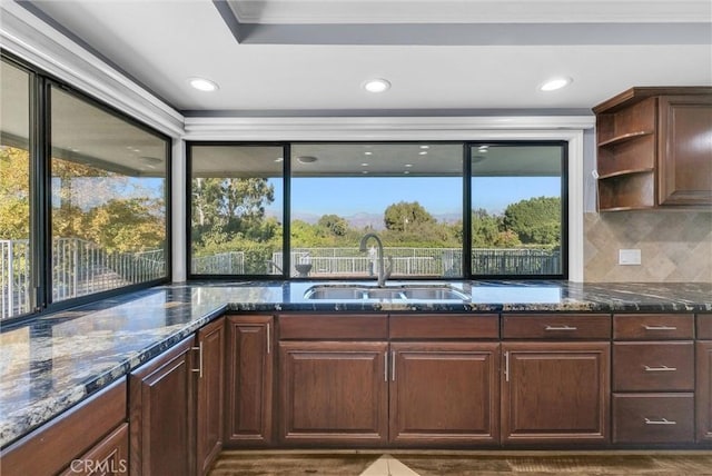 kitchen with dark stone countertops, a wealth of natural light, and sink