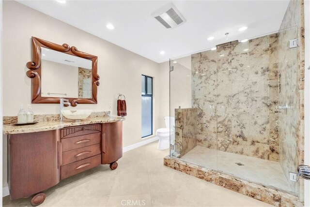 bathroom with tile patterned floors, vanity, toilet, and a shower with shower door