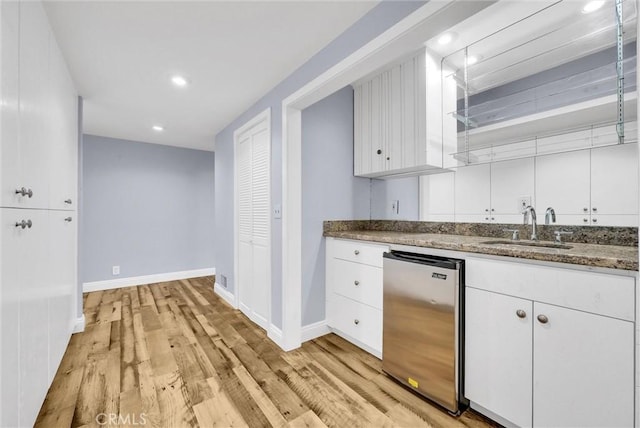 kitchen featuring sink, white cabinets, light hardwood / wood-style floors, and stainless steel dishwasher