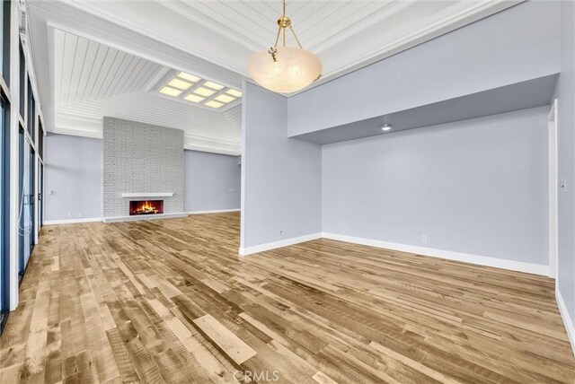 unfurnished living room featuring a fireplace, light hardwood / wood-style floors, and crown molding