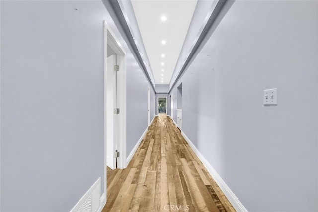 hallway with light hardwood / wood-style floors