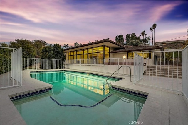 pool at dusk with a patio