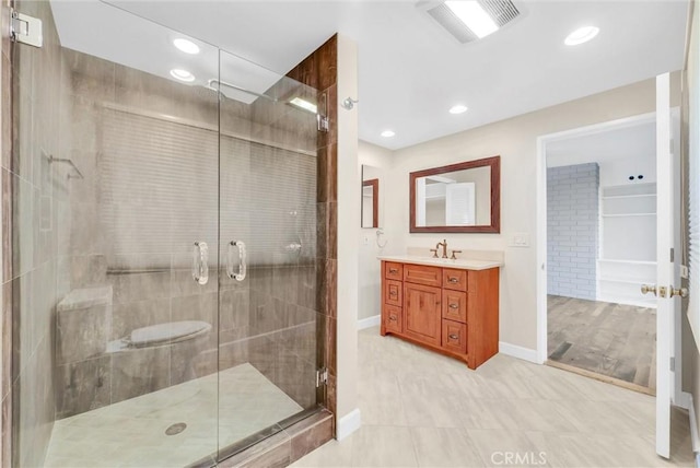 bathroom with tile patterned floors, vanity, and a shower with door